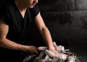 A professional spa massagist performs a relaxing foam massage on a client in a serene indoor setting.